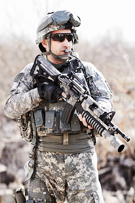 Buy stock photo A soldier standing with gun in hand in a desert environment