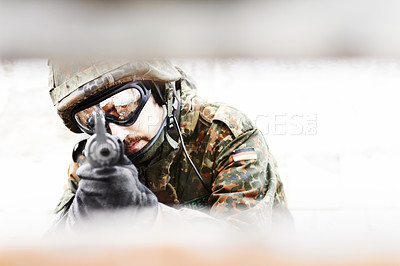 Buy stock photo Closeup of a soldier pointing his gun at the camera through a slot in the foreground