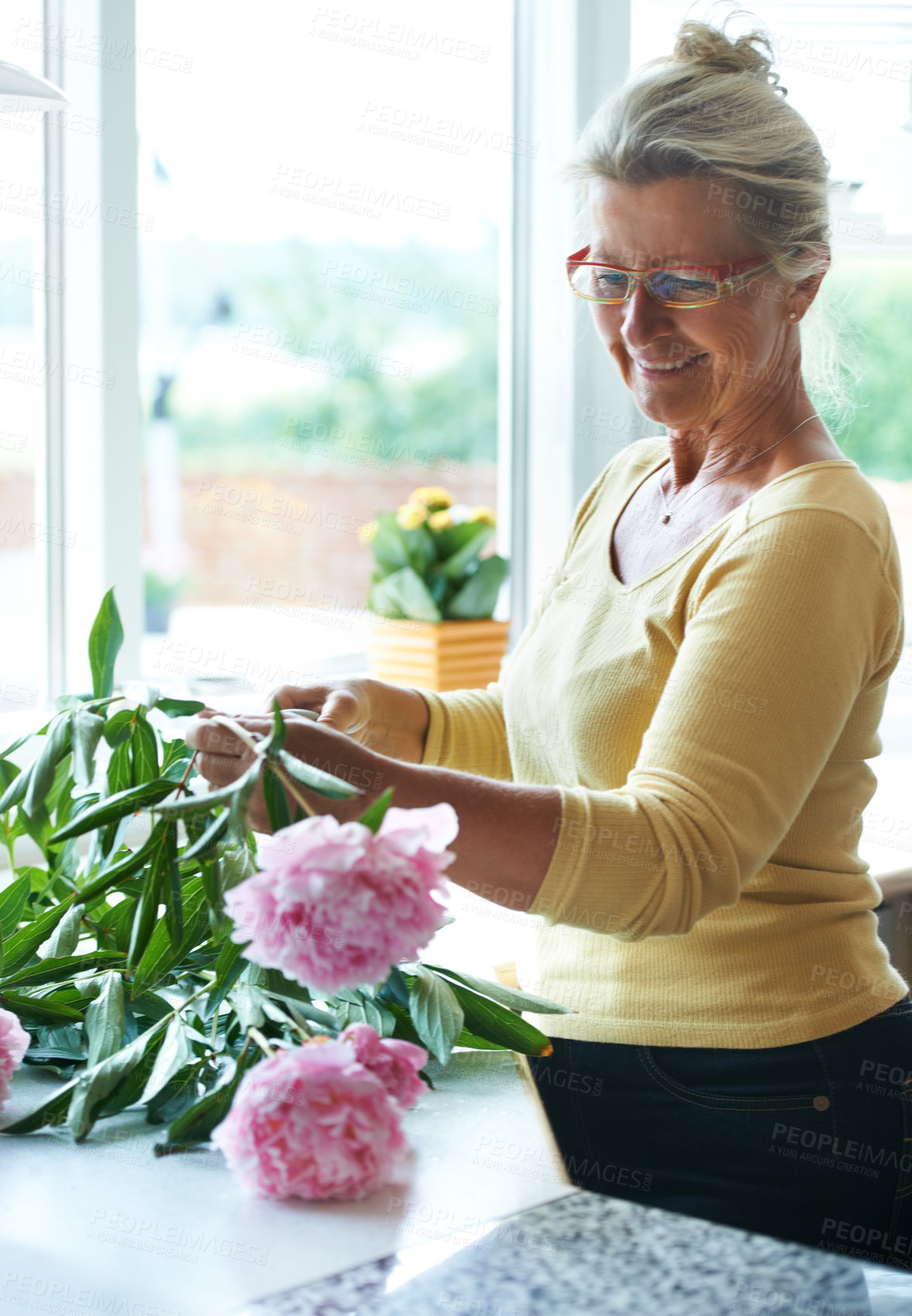 Buy stock photo A happy senior woman making a bouquet of flowers