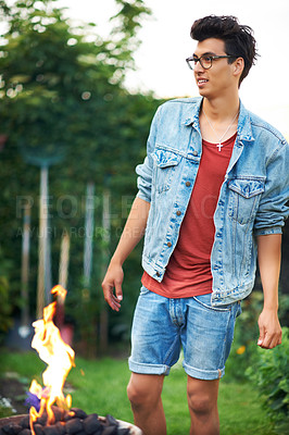 Buy stock photo Man, fire and smile in backyard outdoor for barbecue, celebration or party on grass of house or home. Person, happiness and flame in garden or lawn for bbq, woods  or camping in forest or nature