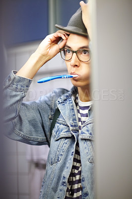 Buy stock photo Trendy young guy getting ready for the day by brushing his teeth