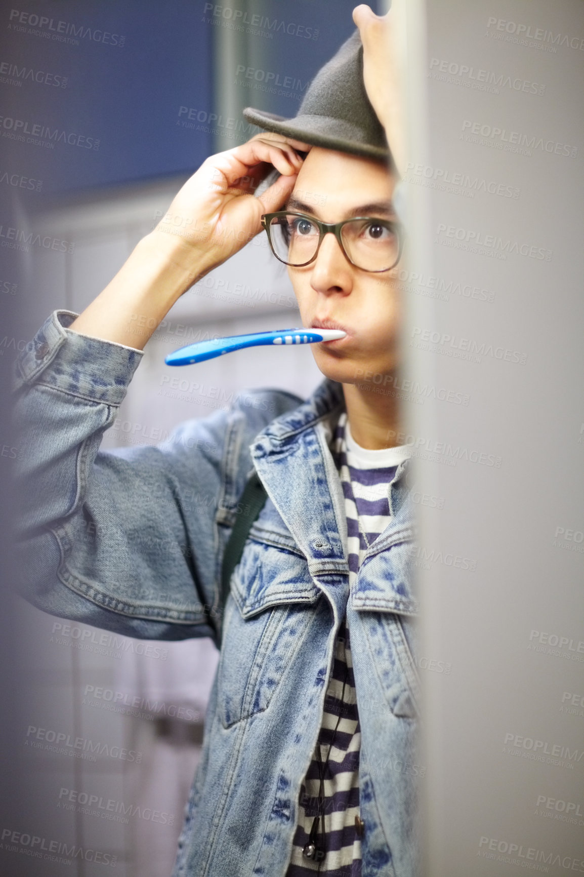 Buy stock photo Trendy young guy getting ready for the day by brushing his teeth