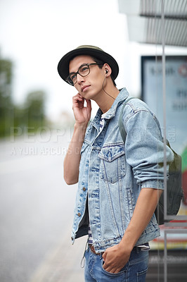 Buy stock photo Man, earphones and listening to music, bus stop and commute or travel, adventure and journey in town. Male person, streaming radio and audio or song, podcast and outdoors for public transport by road