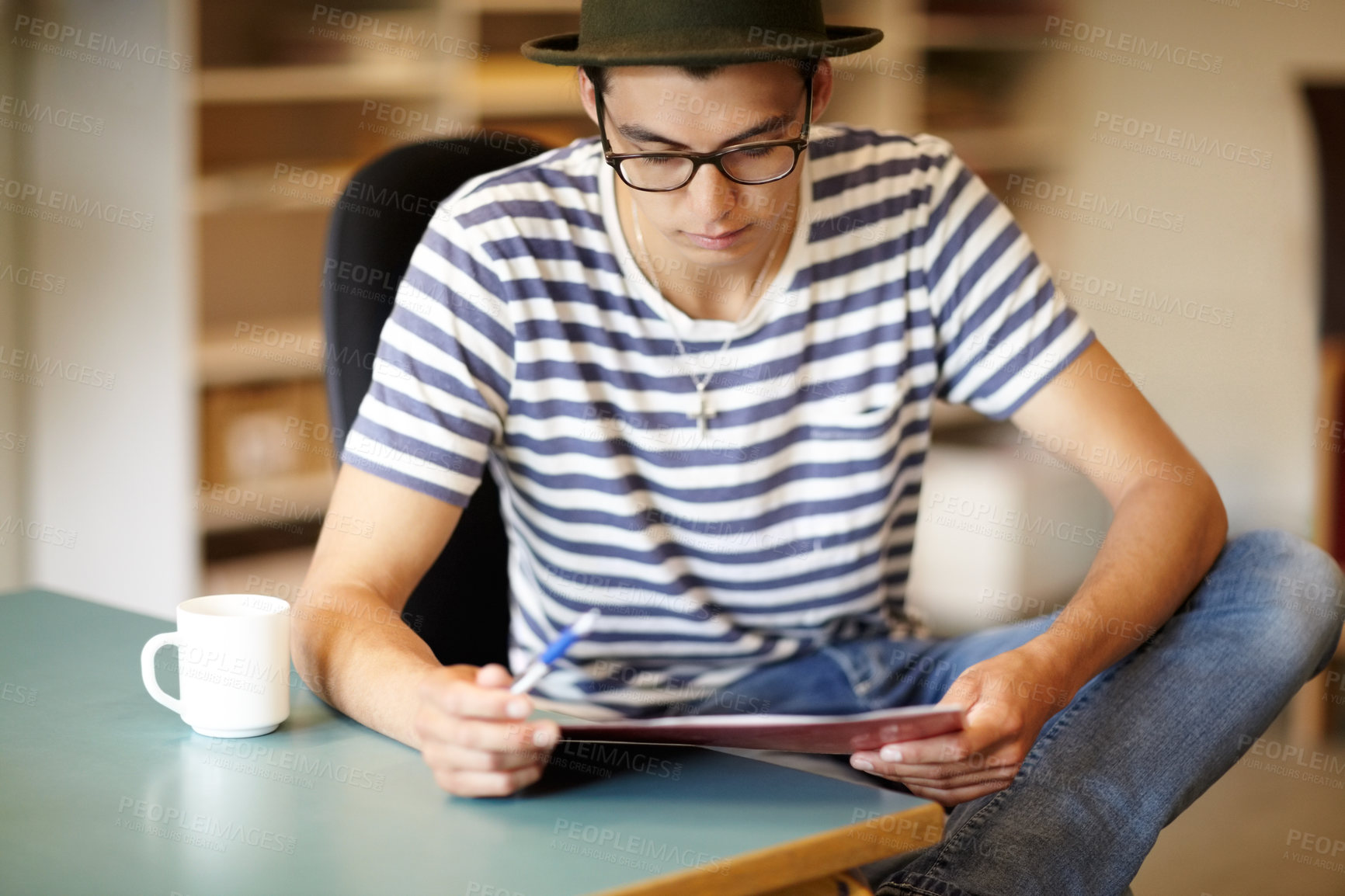 Buy stock photo Young guy looking away while enjoying his morning coffee