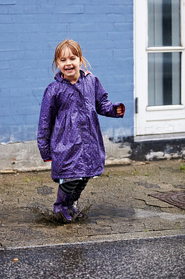 Buy stock photo Child, portrait and splash in mud puddle in raincoat for winter fun, explore city or cold weather happy. Young girl, excited and water on holiday vacation break for wet game or joy, surprise as kid