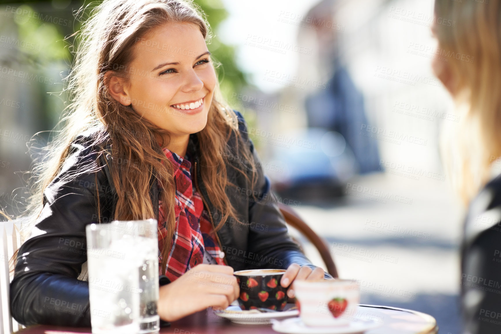 Buy stock photo Two young girlfriends meeting at a restaurant for coffee