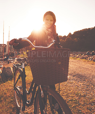 Buy stock photo A beautiful woman standing with her bicycle outside