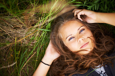 Buy stock photo Serious, portrait and woman relax on grass in nature, countryside or field in environment. Calm, face and person lying on lawn in backyard, garden or meadow with freedom outdoor in spring or summer