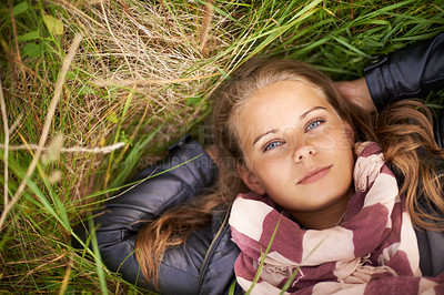 Buy stock photo Serious, portrait and woman relax on grass in nature, countryside or field in environment. Above, face and person lying on lawn in backyard, garden or meadow with freedom outdoor in spring or summer