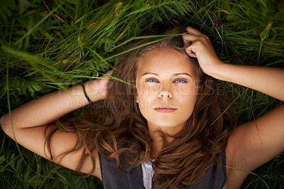 Buy stock photo Portrait of a gorgeous woman lying on her back outside