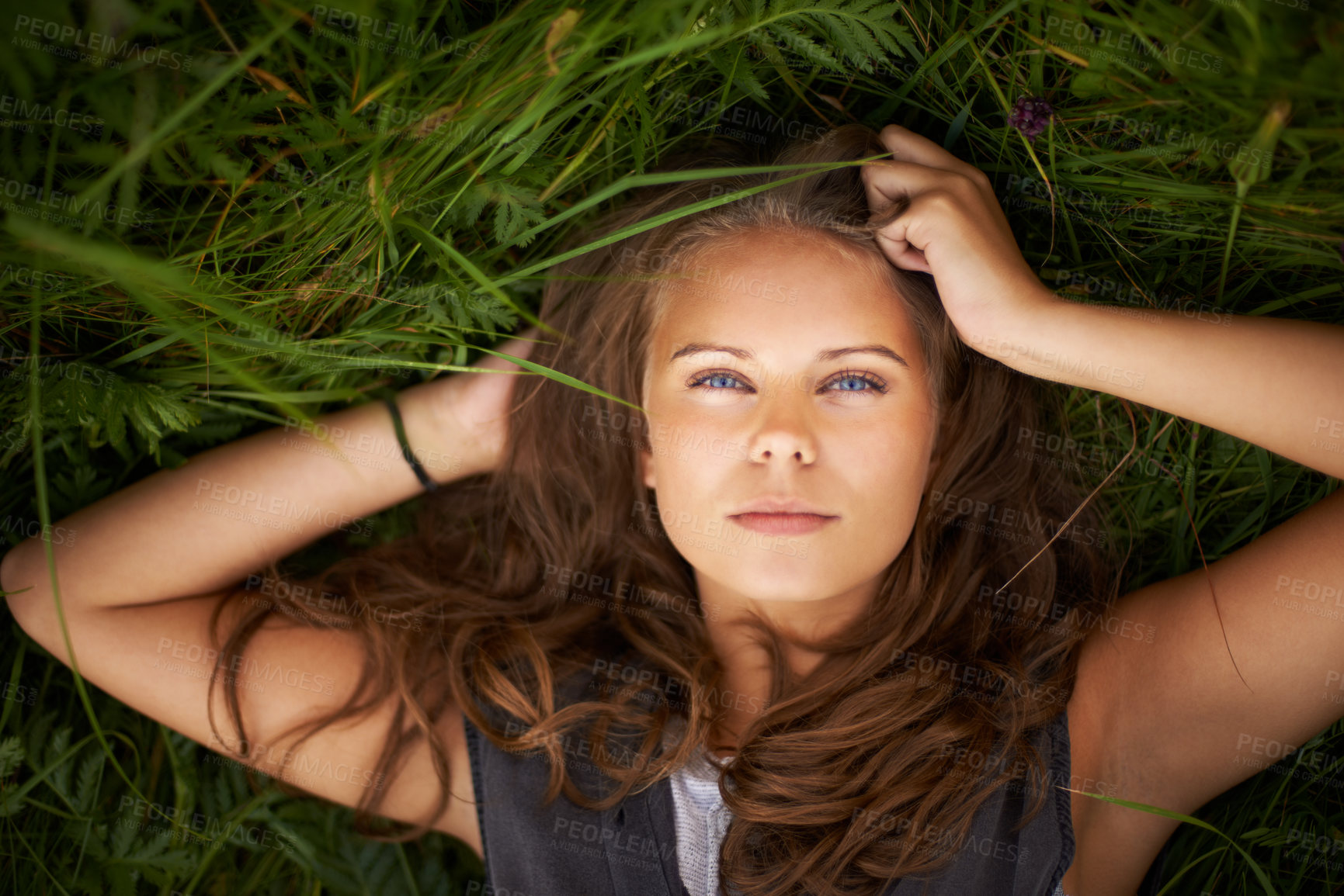 Buy stock photo Portrait of a gorgeous woman lying on her back outside