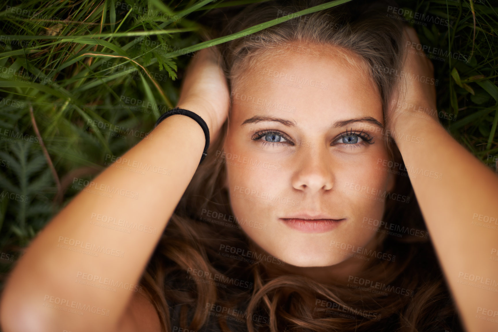 Buy stock photo Portrait, above and beauty of woman on grass outdoor, healthy skin and freedom. Face, top view and young person in nature, green garden and serious attractive girl relax in summer in Switzerland.