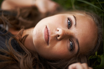 Buy stock photo Portrait, relax and beauty of woman on grass outdoor, healthy skin and freedom. Face, serious and young person in nature, green garden and attractive or confident girl rest in summer in Switzerland