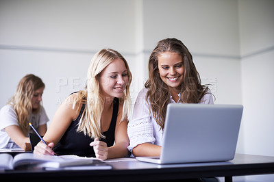 Buy stock photo Two gorgeous teenage girls working on a laptop in class