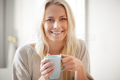 Buy stock photo A pretty young woman enjoying a cup of coffee in the morning