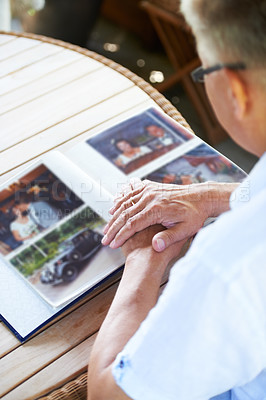 Buy stock photo Photo album, photograph and senior man for memory, reflection and nostalgia in home. Family, retirement and elderly person thinking with picture book to remember past, youth and memories in lounge