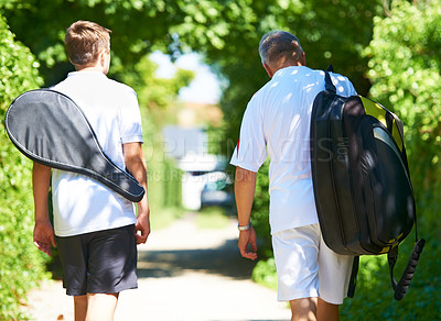 Buy stock photo Walking, man or mature father in tennis training, exercise or game with a bag or racket outdoors. Back view, start or healthy dad with son, athlete or person for sports, wellness or fitness workout