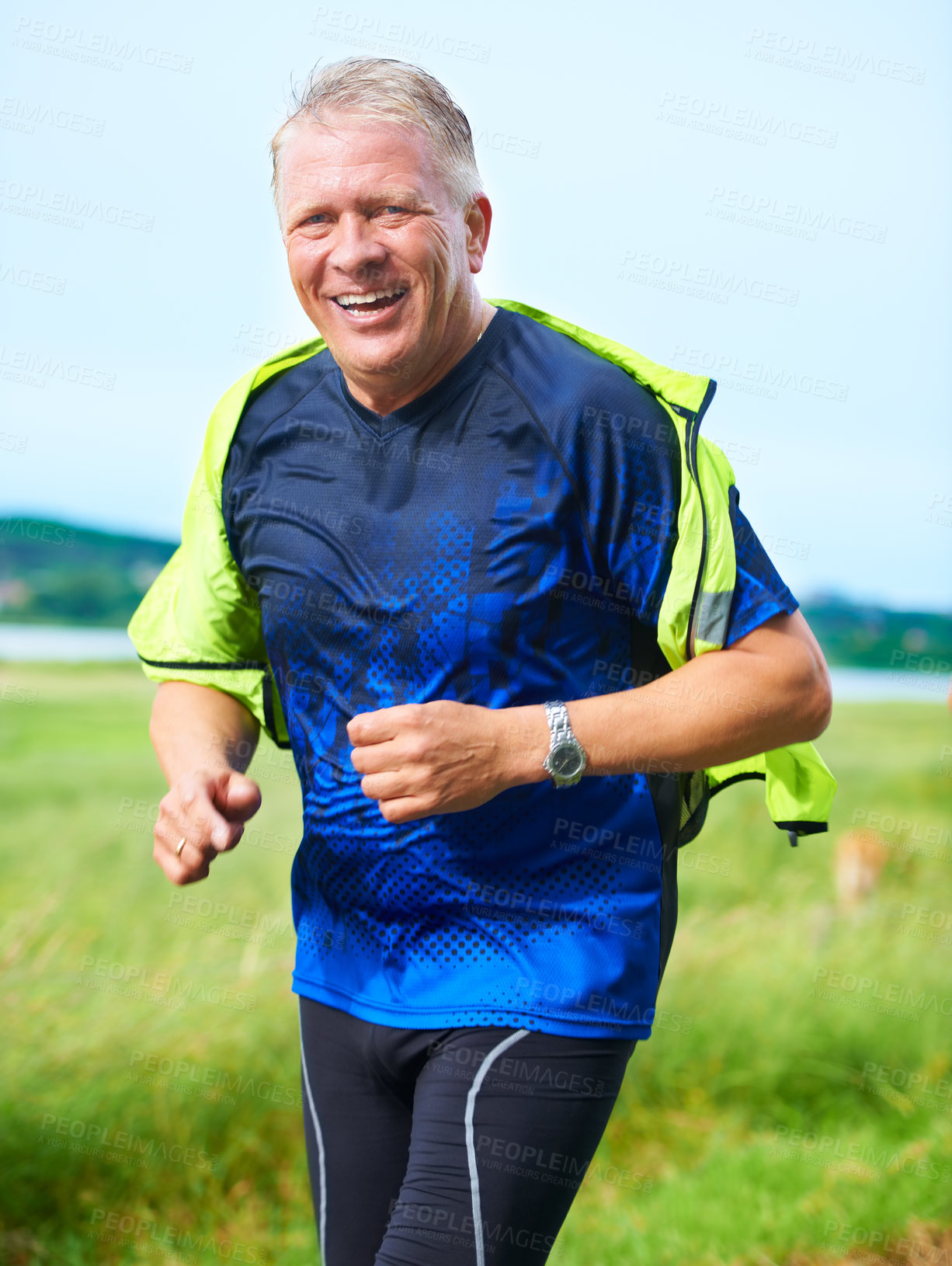 Buy stock photo Portrait, senior or happy man running in nature with smile, fitness or energy outdoors for exercise. Laughing, wellness or healthy mature runner on jog for cardio training or workout on grass in park