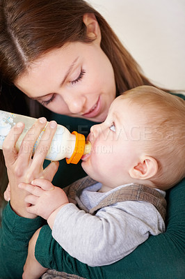 Buy stock photo Woman, holding and baby with bottle for feeding in home for growth, child development or hunger. Mother, son and bond by looking at boy for formula, food or milestone in nutrition, health or diet