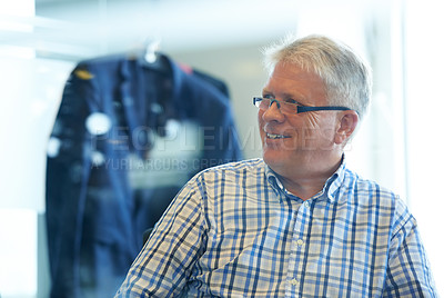 Buy stock photo A senior businessman smiling while sitting in his office