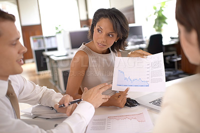 Buy stock photo Shot of three businesspeople discussing graphs in the office