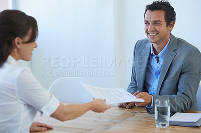 Buy stock photo A pretty young woman handing her resume to a prospective employer at a job interview