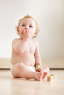 Buy stock photo Cute baby boy looking up curiously while sitting on the floor