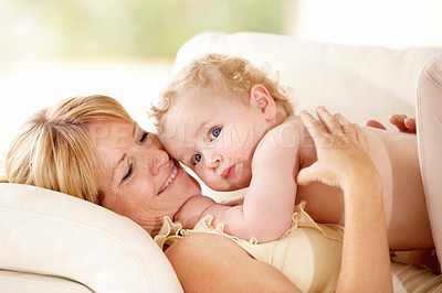 Buy stock photo Baby, mother or holding for love on couch, care support or health wellness with parent happiness. Woman, young child or together with blonde hair, natural bonding or calm relax for growth development