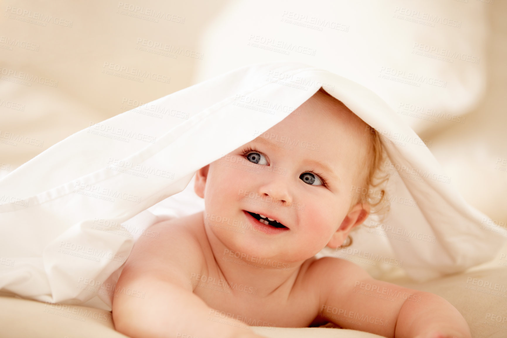 Buy stock photo Smile, face and happy baby on a bed with blanket for playing, games or fun in a nursery room. Learning, child development and curious little boy kid in a bedroom with sheet cover while lying in house