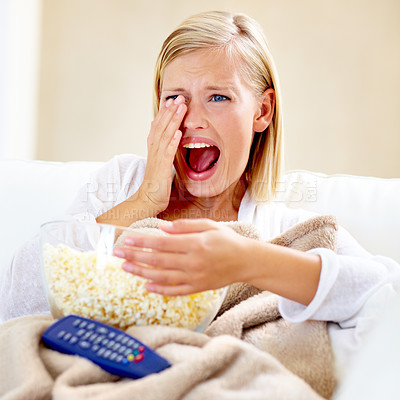 Buy stock photo Horror, popcorn and woman on sofa watching tv with remote, blanket and streaming movies in home. Terror, television and girl on couch in living room with fear for scary video, film or network show.