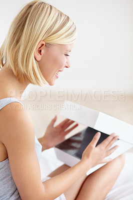 Buy stock photo A beautiful young woman opening a box