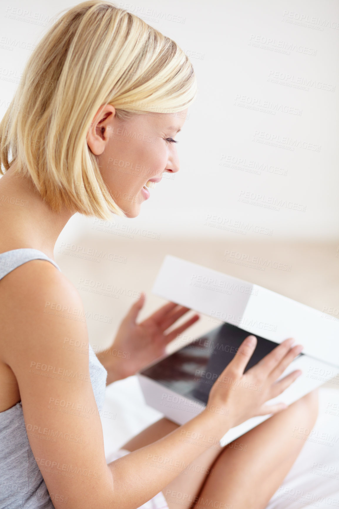 Buy stock photo A beautiful young woman opening a box