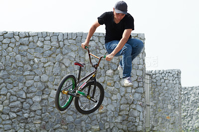 Buy stock photo A BMX rider doing tricks out in the city
