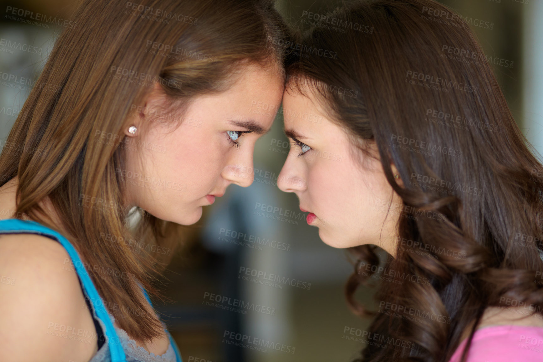 Buy stock photo Cropped shot of two sisters standing face to face in the midst of an argument