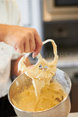 Buy stock photo A bowl of cupcake batter with the Baker holding up the mixer