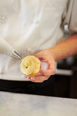 Buy stock photo A baker putting frosting on a cupcake