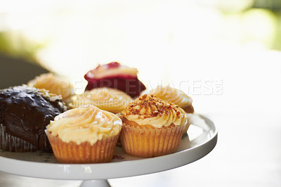 Buy stock photo A tray of an assortment of delicious cupcakes with creamy frosting