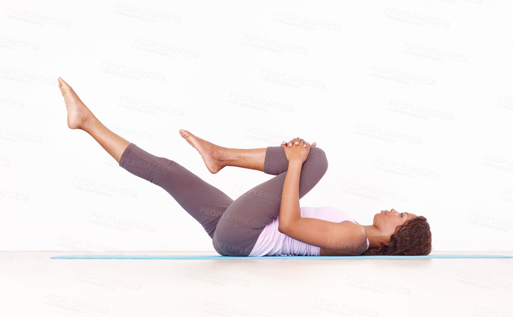 Buy stock photo Yoga, leg stretch and black woman in studio on a fitness and workout mat for training. Isolated, white background and African female person lying on the ground with sport stretching for wellness
