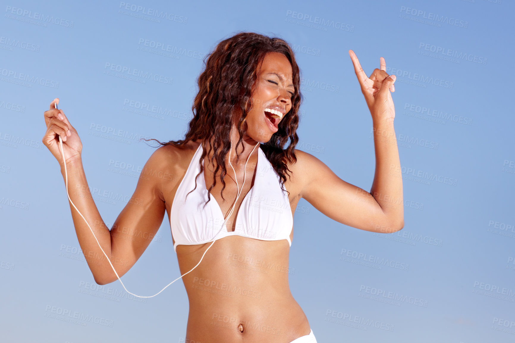 Buy stock photo Black woman, dancing and bikini with holiday and music from happy audio and headphones in studio. Smile, singing and travel with freedom and vacation of African female person with blue background