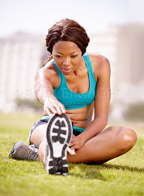 Buy stock photo A pretty young woman stretching her legs before going jogging