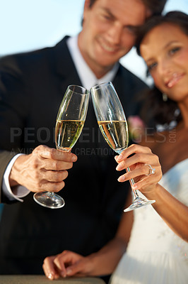 Buy stock photo Cropped view of a young bride and groom standing together and toasting their marriage