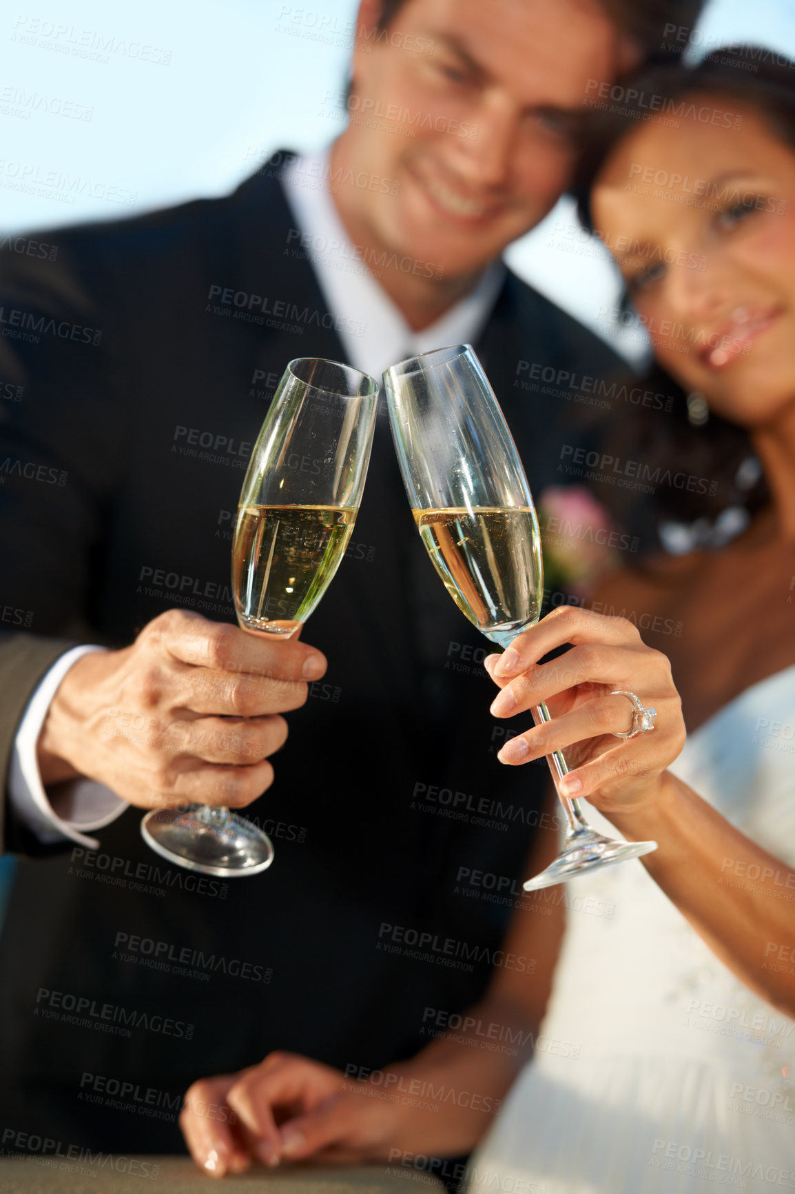 Buy stock photo Cropped view of a young bride and groom standing together and toasting their marriage