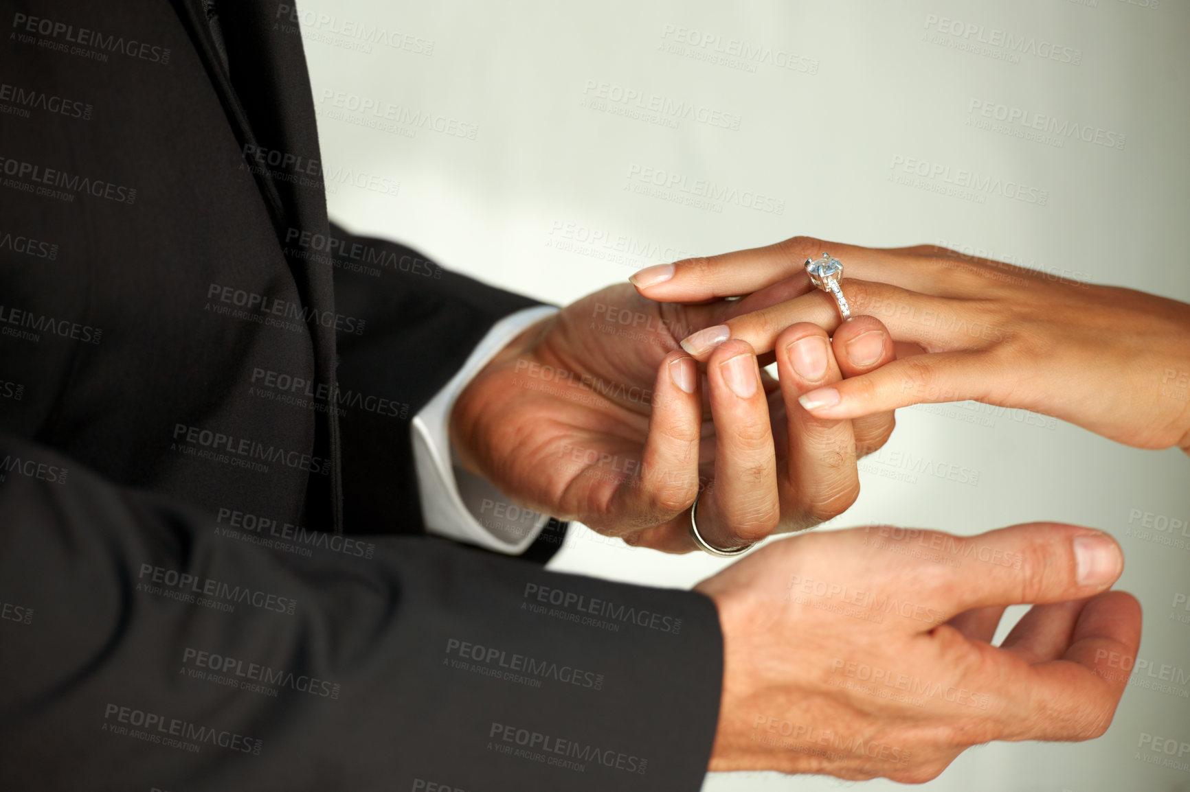 Buy stock photo Couple, bride and ring on hand, commitment and love at wedding, promise and loyalty in marriage. Newlyweds, jewelry and faith or trust in relationship, hope and partnership in closeup of support