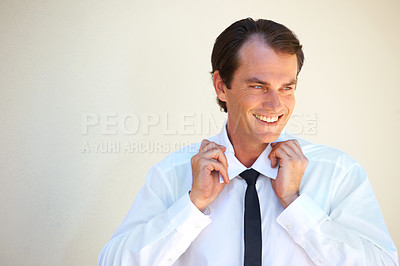 Buy stock photo A handsome man adjusting his tie and collar