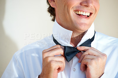 Buy stock photo Cropped image of a happy man adjusting his bow tie