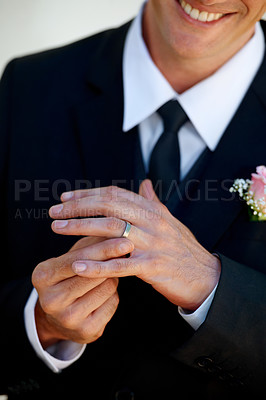 Buy stock photo Hands, groom man and ring for wedding, celebration and commitment to relationship, smile and pride. Person, metal jewelry and tuxedo suit for marriage, happy and closeup at event, party or reception