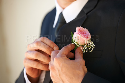Buy stock photo Cropped image of a groom getting adjusting his boutonniere before the wedding ceremony