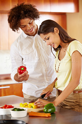 Buy stock photo A young couple cooking together in the kitchen