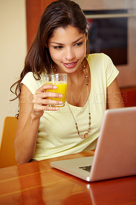 Buy stock photo Morning, laptop and woman doing remote work with juice for breakfast in a home. Table, online and working freelancer with social media scroll and computer with a smile from technology in a house