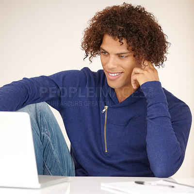 Buy stock photo Laptop, student and man online in studio for research, internet and reading news on website. Happy, university and person on computer for connection, elearning and education on white background